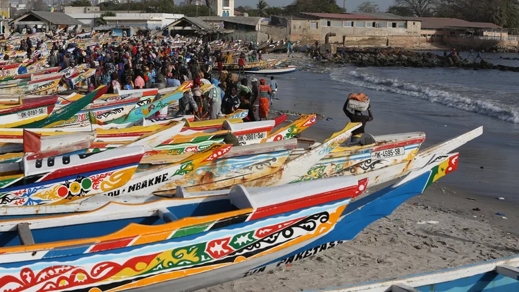 Pirogues colorées alignées sur la plage au Sénégal.
