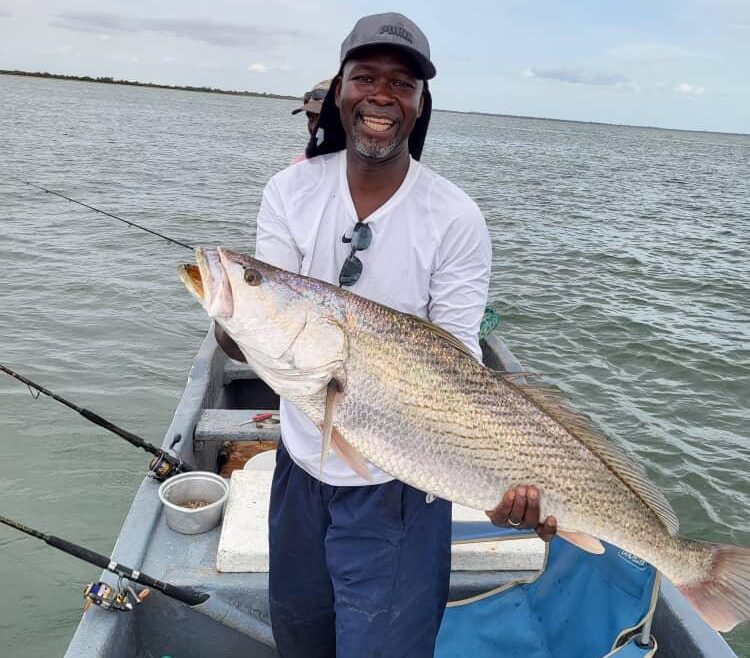 Client canadien de Teranga Découvertes tenant une otolithe (ombrine) capturée lors d'une session de pêche au Sine et Saloum, Sénégal.