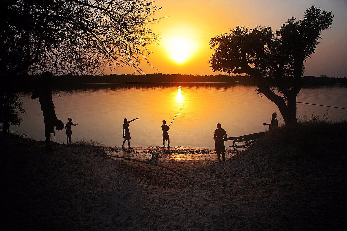 Pêcheur au coucher du soleil pêchent depuis la berge dans le delta du Sine et Saloum