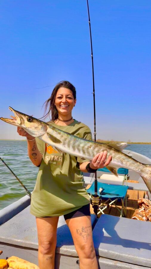 Pêcheuse tenant un barracuda capturé dans le delta du Sine et Saloum